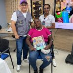 Felipa posa sonriente junto al equipo del programa Camino de Oportunidades sosteniendo su cartilla de formación.