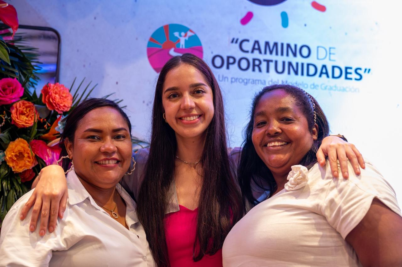 Carlota Arias, directora de programas, posa con dos mujeres miembros del equipo de Grupos de Ahorro en la ceremonia de graduación del programa Camino de Oportunidades.