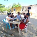 Grupo de mujeres sentadas al aire libre participando en un taller del programa Caminos al Bienestar.