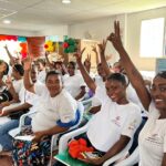 Familias participantes levantan la mano durante la entrega de capital semilla en Cartagena.