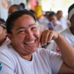 Mujer participante sonríe en entrega de capital semilla de Camino de Oportunidades.